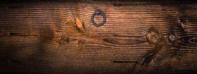 gray metal door knocker on wooden panel