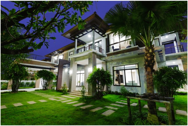 large well lit home and yard tropical palm trees