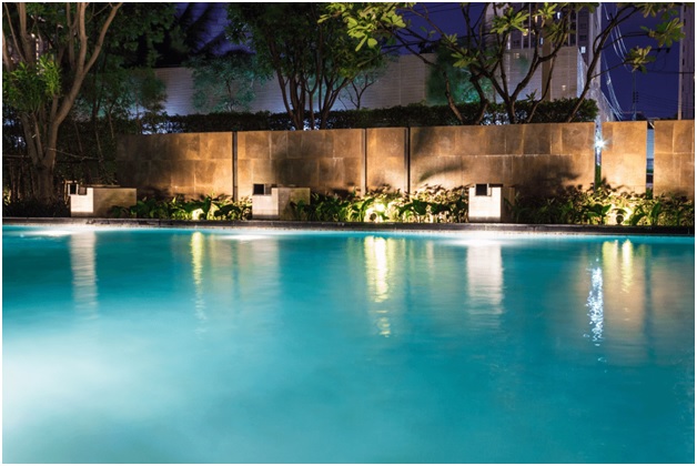 tropical pool area with lights in the water and on the ground